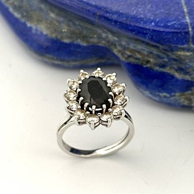an image of a black diamond ring sitting on top of a blue stone