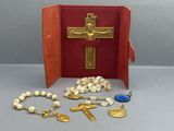a red book with a cross, rosary, and other religious items
