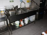 a kitchen with a sink and a counter with pots and pans on it