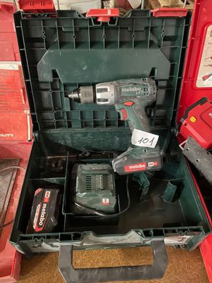 a cordless drill in a tool box with other tools in it