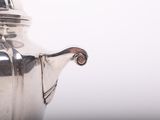 a silver tea pot sitting on a white table