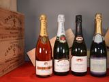 several bottles of wine are lined up on a red table