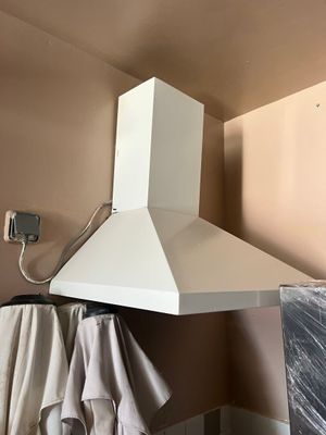 une photo d'une cuisine avec une cuisinière et une hotte murale