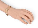 an image of a woman ' s hand with a gold chain bracelet