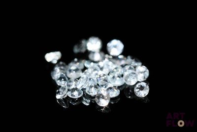some white diamonds on a black surface with a black background