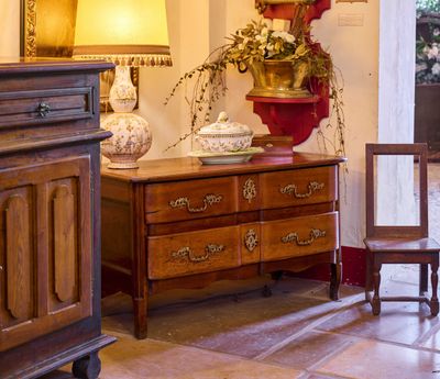 une commode en bois et une lampe dans une pièce