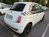 a small white car that is parked in a parking lot