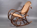 un fauteuil à bascule en bois avec une assise en osier sur fond gris