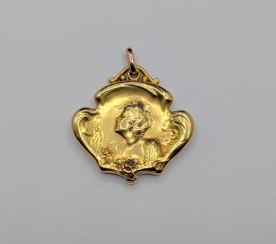 gros plan d'une médaille d'or sur une surface blanche