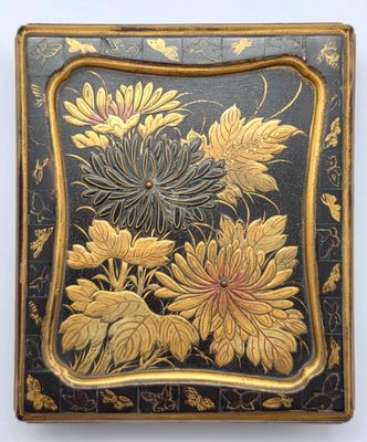 une boîte ancienne peinte en noir et or, ornée de fleurs