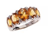 un gros plan d'une bague à trois pierres sur fond blanc
