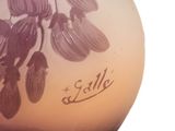 a purple vase with flowers on it sitting on a table