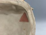 a close up of a white vase with a red triangle on it