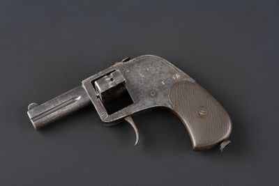 un vieux pistolet posé sur une surface noire, avec un fond noir