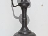 a black vase with a handle on a white table