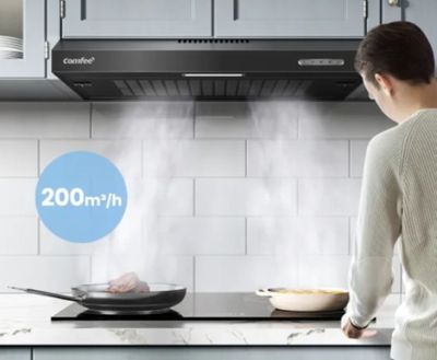 un homme debout dans une cuisine, avec une poêle posée sur la cuisinière