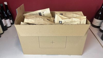 une boîte remplie de sachets de café posée sur un comptoir