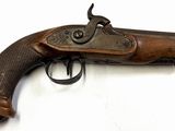 un gros plan d'un pistolet sur une surface blanche avec un fond blanc