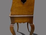 a small wooden chair with a heart shaped hole in the back