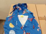 une chemise bleue posée sur une table, à côté d'une paire de ciseaux