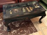 une table en verre sur laquelle est posé un tableau, dans un salon