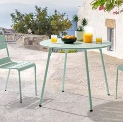 une table avec deux chaises et un bol de fruits posé dessus