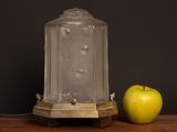 an apple sitting next to a glass lamp on a table