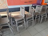des tables et des chaises dans un restaurant, avec un mur en briques en arrière-plan