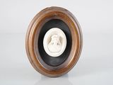 une photo représentant une statue de femme, dans un cadre en bois
