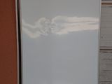 a white refrigerator sitting in a garage next to a wall