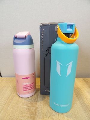 two water bottles sitting on a table next to each other