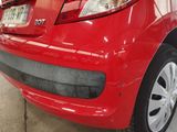 a red car parked in a garage with a license plate on it