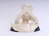 a figurine of a woman sitting on a table