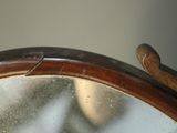 a close up of a mirror with a wooden handle on it