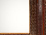 an old wooden frame with a mirror hanging on it ' s wall