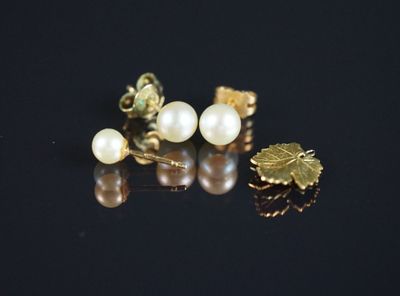 trois paires de boucles d'oreilles en perles et en or sur un fond noir