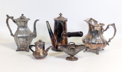 trois théières en argent et une cafetière sur une table