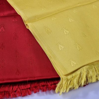 yellow and red scarfs on a bed with a red and yellow blanket