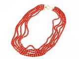gros plan d'un collier de perles rouges sur fond blanc