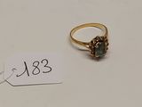 l'image d'une bague en or ornée d'une pierre verte