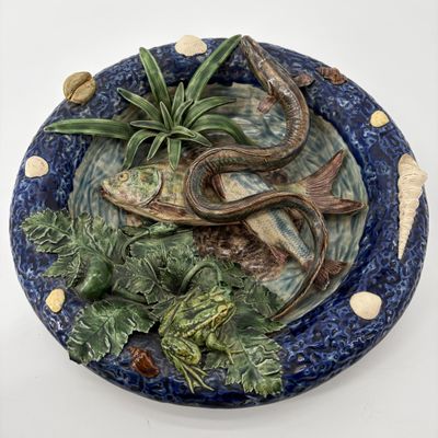 une assiette bleue décorée d'un poisson et de plantes