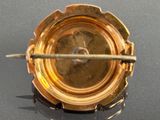 a close up of a gold plate with a needle sticking out of it
