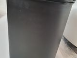 a black trash can sitting on top of a white counter