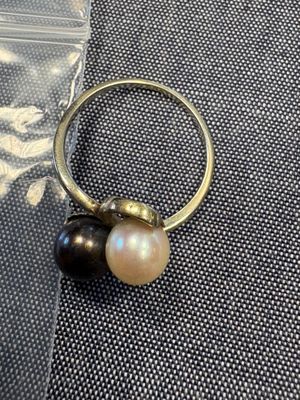 un gros plan d'une bague ornée de deux perles