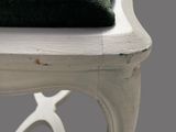 a white chair with a green cushion on top of it