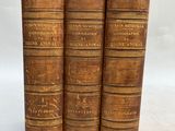 a set of three old books sitting on top of each other