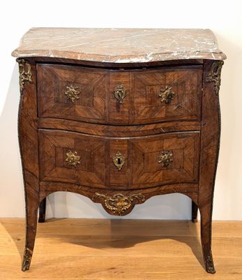 a marble top chest of drawers on a wooden floor