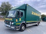 un camion vert garé sur un parking
