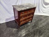 a small marble top chest of drawers on a stand
