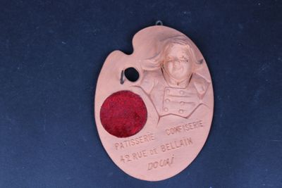 une médaille sur laquelle figurent l'image d'un homme et un point rouge